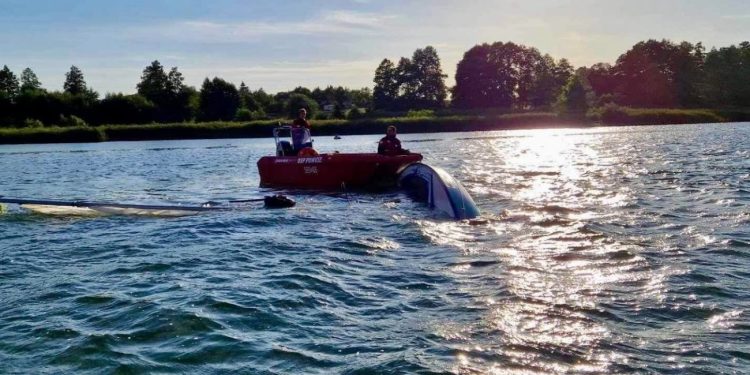 Wywrócona łódź, jedna osoba w wodzie