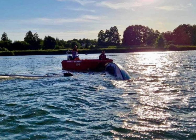 Wywrócona łódź, jedna osoba w wodzie